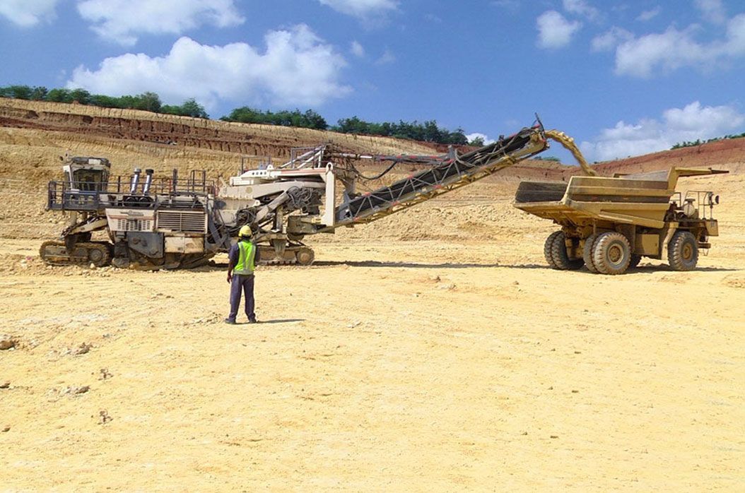 Mining trucks and a crusher in an open quarry