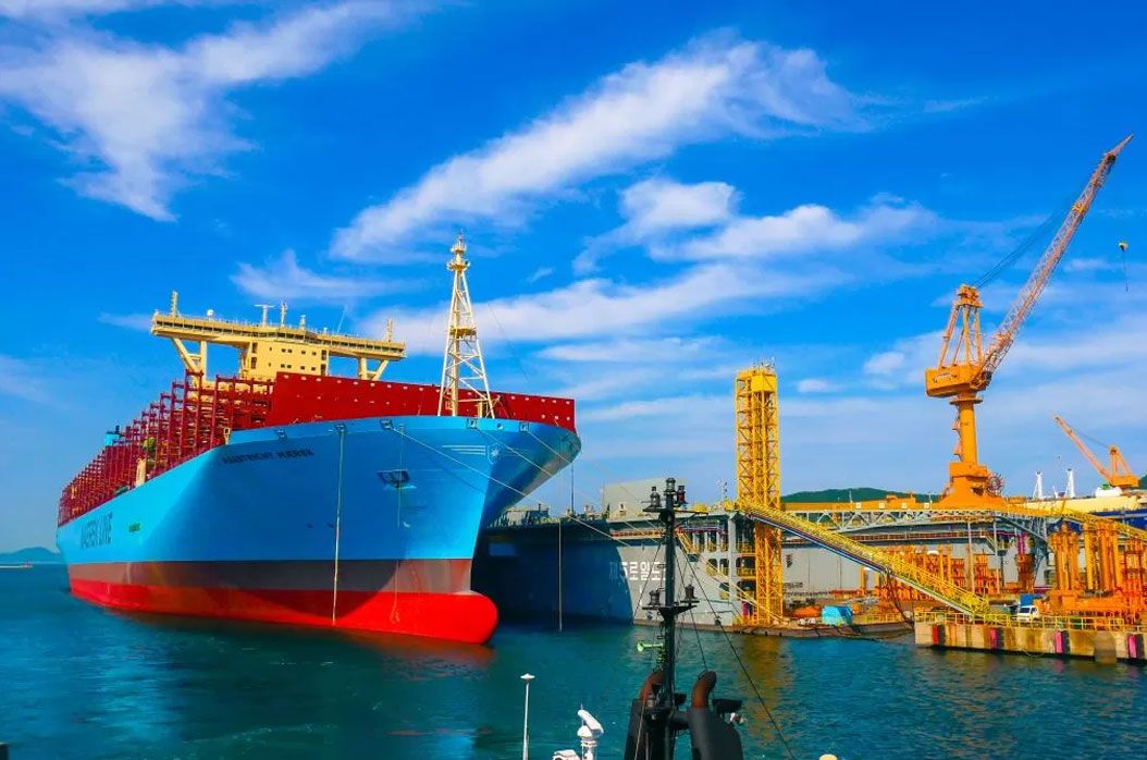 Cargo ship beside port cranes